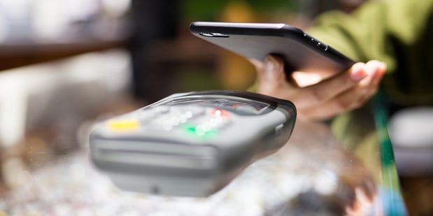 Woman paying with smartphone by NFC.jpg